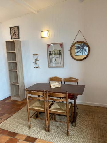 a dining room table with two chairs and a mirror at Plein Ciel Vue Bassin in Arcachon