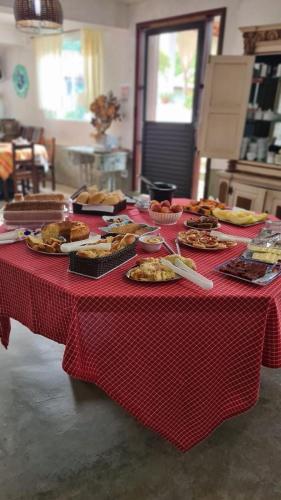 un tavolo rosso e bianco con piatti di cibo sopra di Pousada Cachoeira a Serra Negra