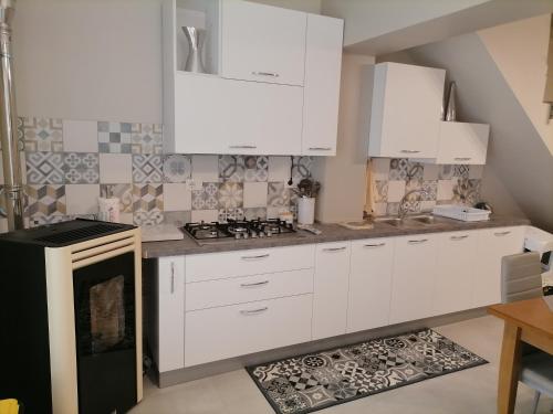 a kitchen with white cabinets and a stove at SoleLuna in Santa Elisabetta
