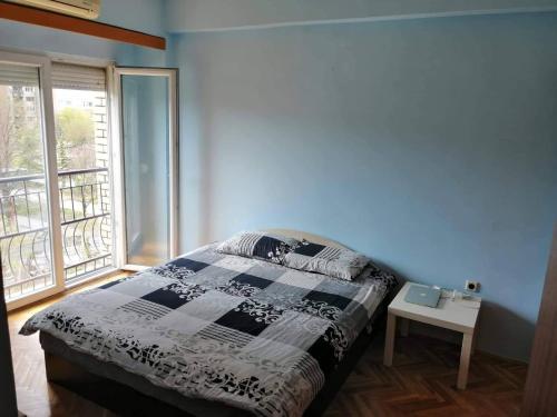 Un dormitorio con una cama y una ventana y una mesa. en Centar Apartments, en Skopje