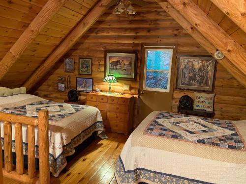 Harpers FerryにあるCarries Cabinのログキャビン内のベッドルーム1室(ベッド2台付)