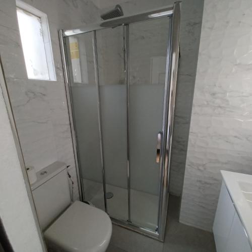 a bathroom with a shower with a toilet and a sink at Ezz'Hotel Canet in Canet-en-Roussillon