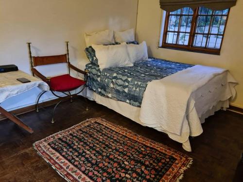 a bedroom with a bed and a chair and a rug at Quaint, quiet retro charm in Johannesburg