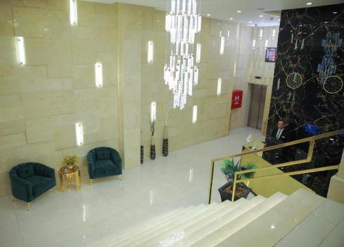 a man in a lobby with chairs and a chandelier at Park Plaza Hotel in Amman