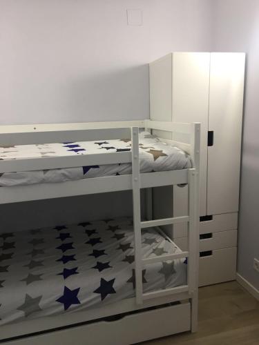 a bedroom with a bunk bed with stars on the floor at Apartamento a 50 mts playa con piscina en Blanes muy céntrico y acogedor. in Blanes