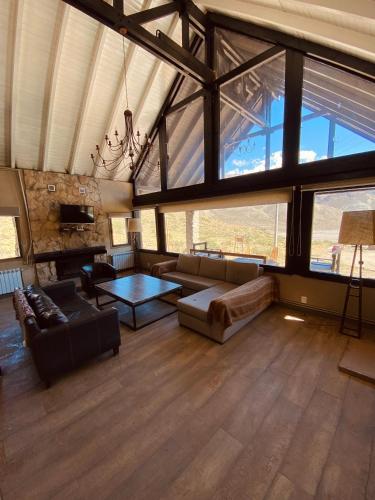a large living room with a couch and a table at Casas De Montaña Las Leñas Los Molles in Los Molles