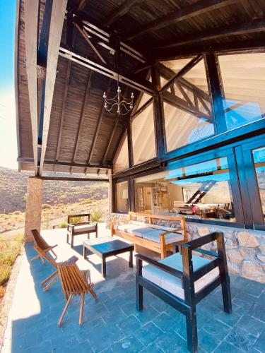 a house with a table and chairs on a patio at Casas De Montaña Las Leñas Los Molles in Los Molles