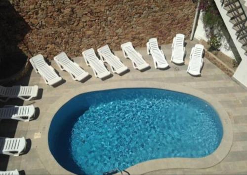 a group of chairs and a swimming pool at Apartamento a 50 mts playa con piscina en Blanes muy céntrico y acogedor. in Blanes