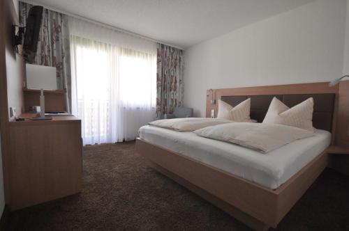 a bedroom with a large bed and a window at Hotel-Pension-Jasmin in Rheinfelden