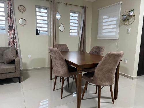 a dining room with a wooden table and chairs at Brebella New 2 Bedroom Apartment in Willemstad