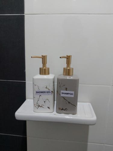 two bottles ofodorizers sitting on a sink in a bathroom at The Viana Apartment 1 in Kota Bharu