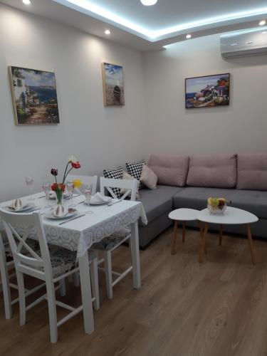 a living room with a table and a couch at Апартамент Амира 3 in Balchik