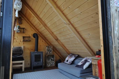 um quarto com um sofá e um fogão numa cabina em Domek na Drzewie! em Rudka Gołębska