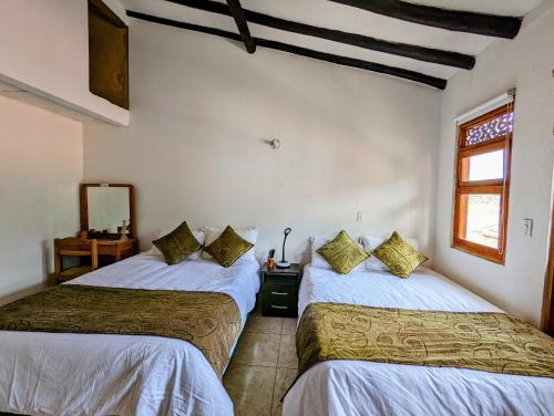 een slaapkamer met 2 bedden en een raam bij Casa de Huéspedes Faletto in Villa de Leyva