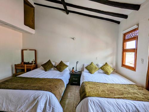 a bedroom with two beds and a window at Casa de Huéspedes Faletto in Villa de Leyva