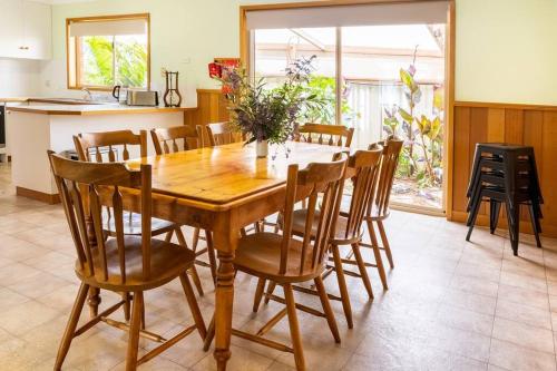 a dining room with a wooden table and chairs at The Clydesdale - Spacious 4 bedroom Home in Echuca
