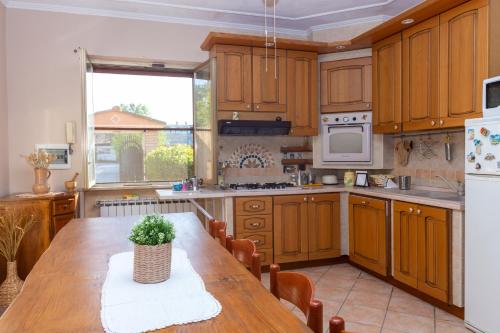 Una cocina con gabinetes de madera y una mesa de madera. en Villetta indipendente vicino aeroporto, en Fiumicino