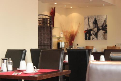 a dining room with tables and chairs with red table cloth at Arena Hotel in Henstedt-Ulzburg