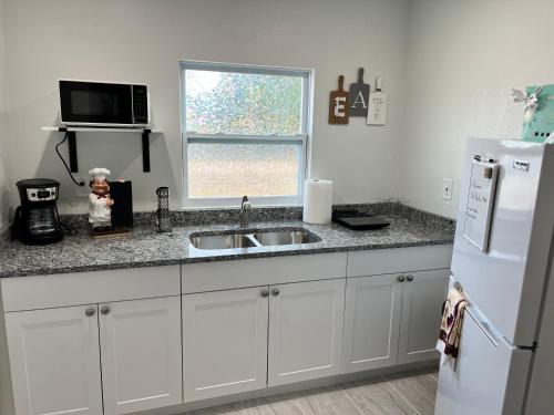 a kitchen with a sink and a white refrigerator at VillaBella in Fort Myers