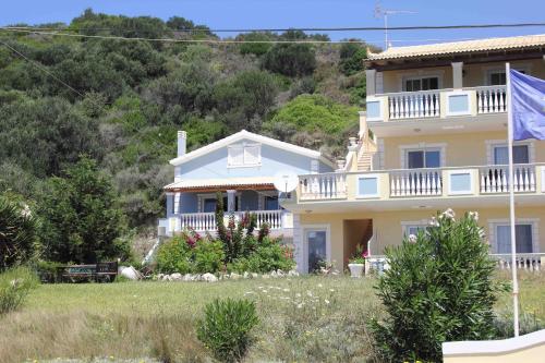 a large house with a flag in front of it at SAN GEORGE COVE in Afionas