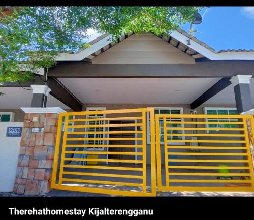 a yellow gate in front of a house at TheREHAT Homestay Kijal Terengganu in Kijal