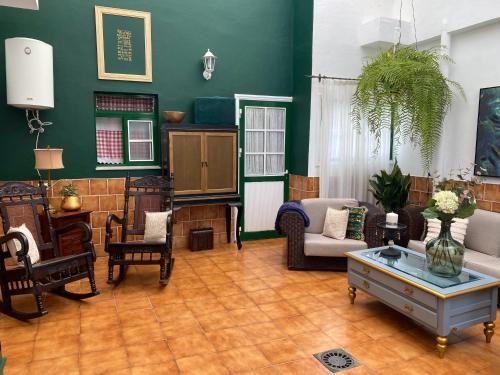 a living room filled with furniture and a green wall at Casa Charry in Tegueste