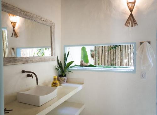uma casa de banho com um lavatório e um espelho em Casa da mata em Porto Seguro