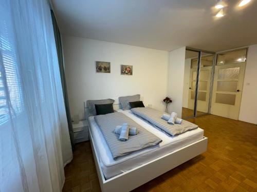 Un dormitorio con una cama con dos almohadas encima. en Apartment Green - Grey, en Liubliana