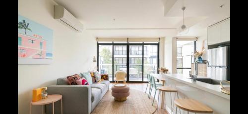 a kitchen and living room with a couch and a table at The Pas.Coe - A Stylish 1 bedroom unit with free parking. in Melbourne