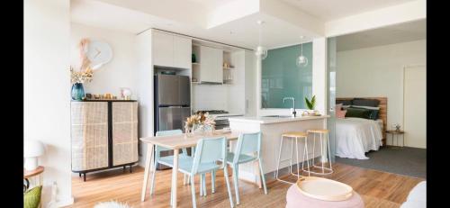 a kitchen and living room with a table and chairs at The Pas.Coe - A Stylish 1 bedroom unit with free parking. in Melbourne