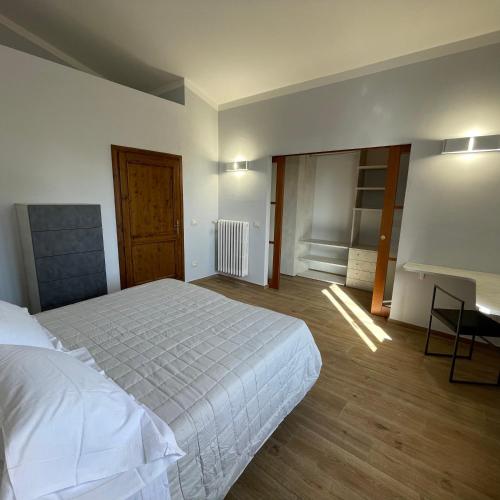 a bedroom with a white bed and a desk at Residenza San Donato in Montepulciano