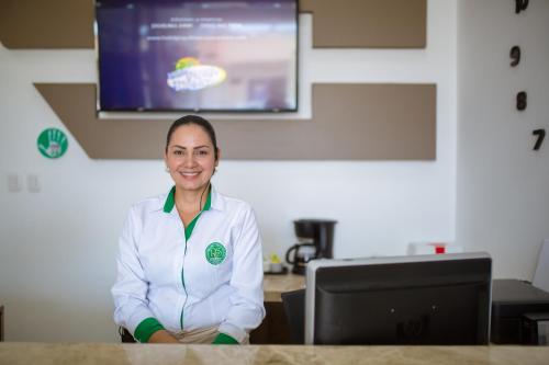 a woman sitting at a desk in front of a computer at Hotel Ribera Sinu in Montería