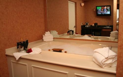 a bathroom with a tub with towels and a mirror at Heritage Hills Golf Resort & Conference Center in York