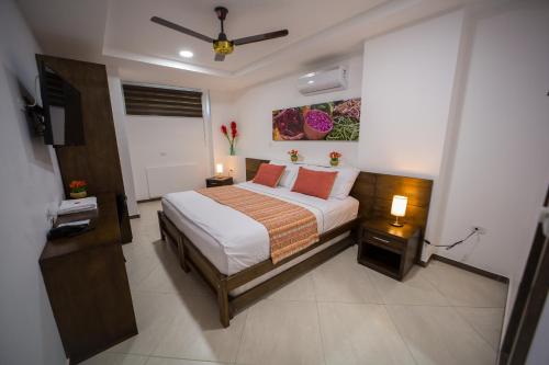 a bedroom with a bed and a tv in it at Hotel Ribera Sinu in Montería