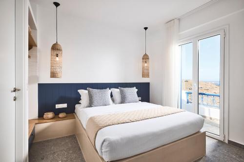 Un dormitorio con una cama grande y una ventana en Tramontana Suites, en Áyios Stéfanos