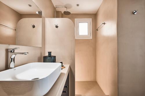 a bathroom with a sink and a mirror at Tramontana Suites in Áyios Stéfanos