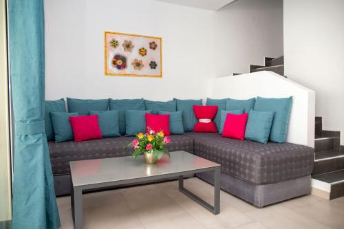 a living room with a couch with pink and blue pillows at Hotel Oasis-Dream Holidays - La Petite France in San Bernardino