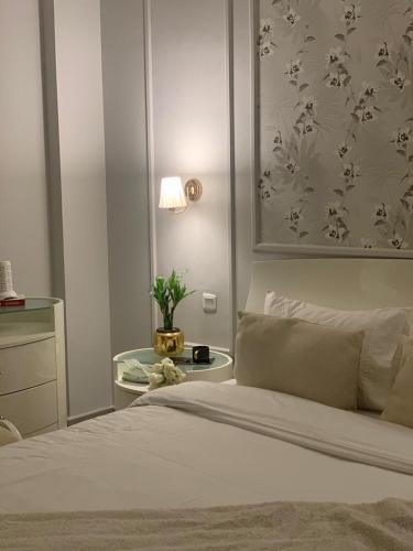 a bedroom with a bed and a table with a plant at شقة في مدينة الملك عبدالله الاقتصادية حي الشروق in King Abdullah Economic City