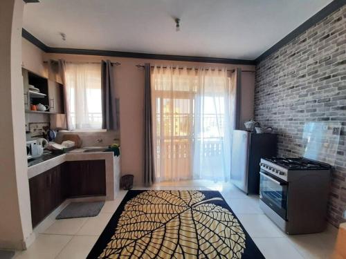 a kitchen with a stove and a brick wall at Macy's Studio Apartment in Mto Panga