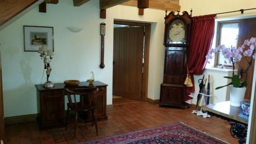 a room with a grandfather clock and a table at Ty Derw Country House B&B in Ruthin
