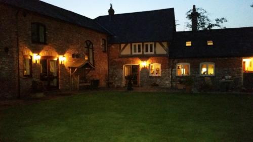 a large brick house with lights in the yard at Ty Derw Country House B&B in Ruthin