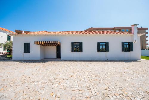 a large white house with a brick driveway at Casas São João by Ana Ferro Rentals in Arcozelo