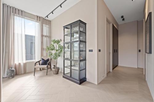 a hallway with a glass book shelf and a chair at T23 Penthouse Suite - Reykjavík in Reykjavík