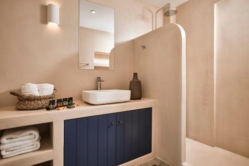 a bathroom with a sink and a mirror at Tramontana Suites in Áyios Stéfanos