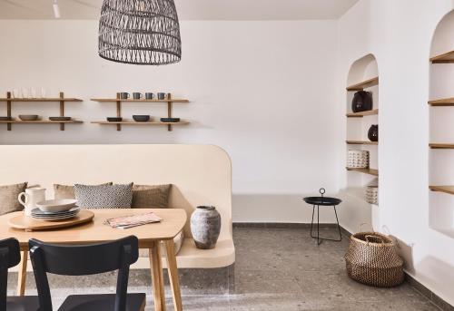 a living room with a table and a couch at Tramontana Suites in Áyios Stéfanos