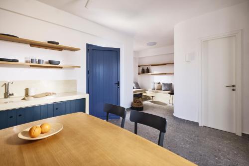 a kitchen with a table with a bowl of fruit on it at Tramontana Suites in Áyios Stéfanos