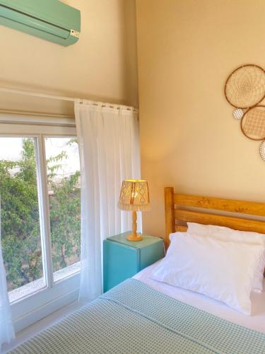 a bedroom with a bed and a window at Alaca Butik Otel in Cesme