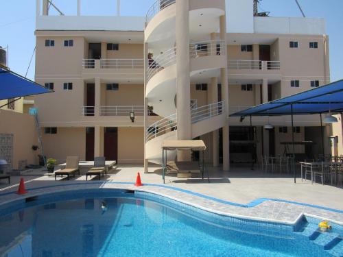 a swimming pool in front of a apartment building at DEL VALLE HOUSE II in Ica