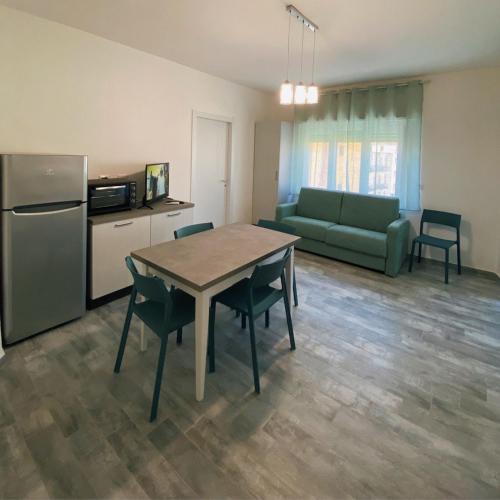 Una cocina y una sala de estar con una mesa y un sofá. en PM 29 Guest House, en Alghero
