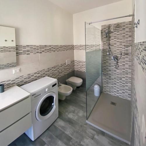 y baño con lavadora y ducha. en PM 29 Guest House en Alghero
